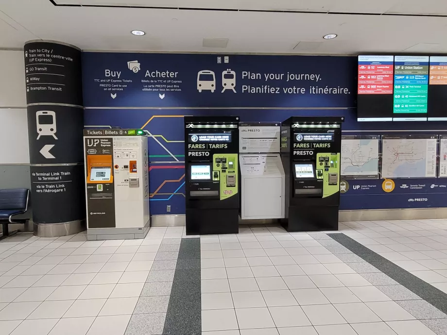 Bilietų automatai. UP Express traukinys kairėje, autobusai dešinėje