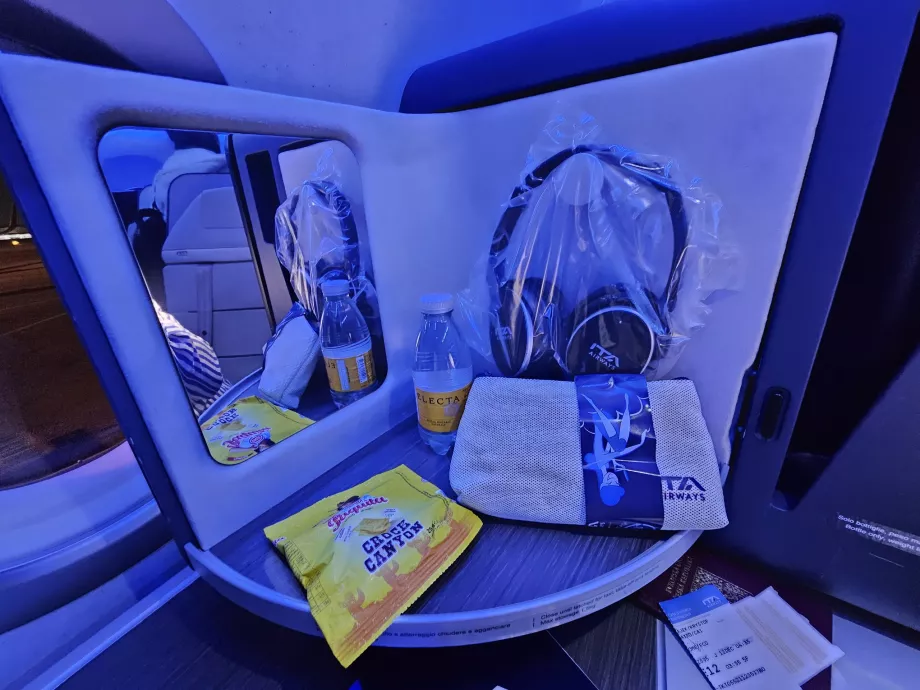 Atidarymo skydelis su veidrodžiu, ausinėmis, sausainiais ir vandeniu