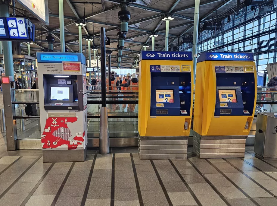 Bilietų automatai: geltoni - traukiniui, baltai raudoni - autobusui, traukiniui ir metro.