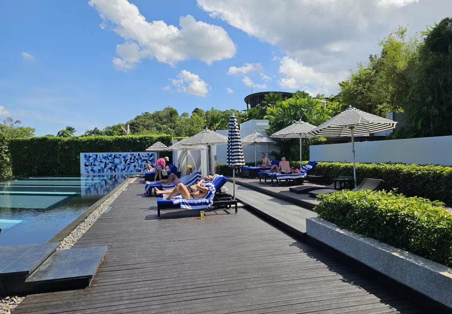 Šezlongai prie bendro baseino